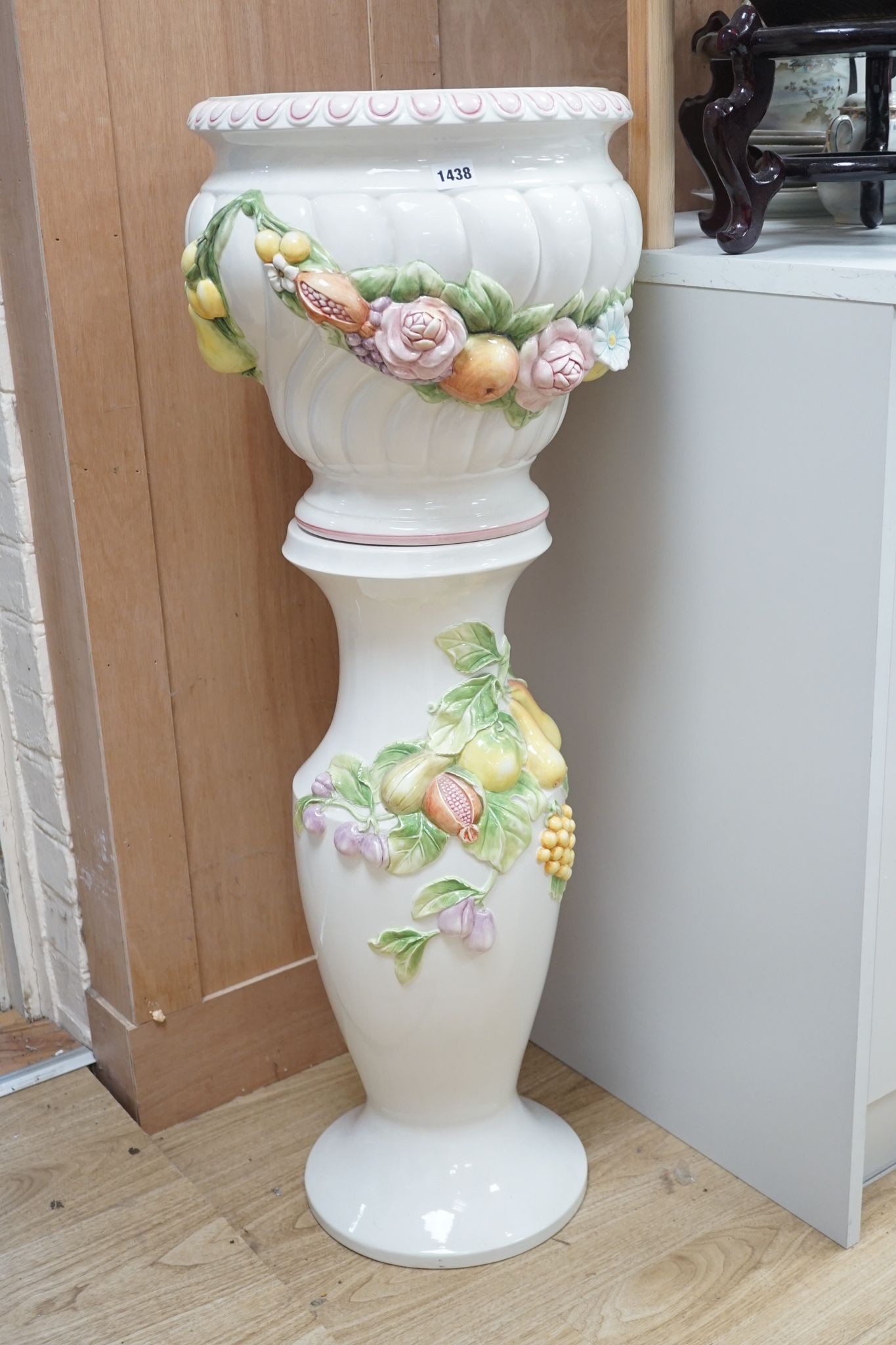 A modern Italian pottery jardiniere and stand, with floral and fruit decoration, 104 cms high.